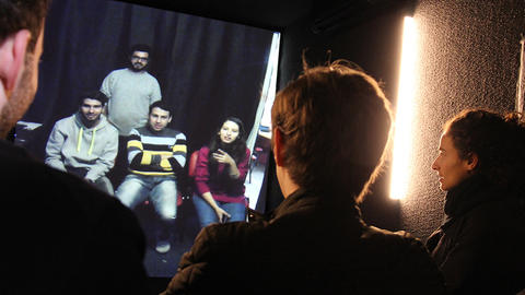 Several students chatting with four refugees via video conference