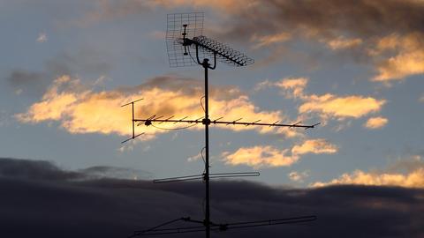 An antenna in the shape of a cross at sunset. Photo by Hans from Pixabay.