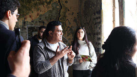 Students gathered inside a historic stone building listening to their guide