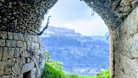 Views of distant landscape through a stone arch