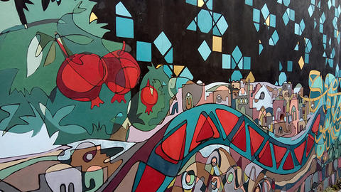 Mural painting of pomegranates and landscape with buildings