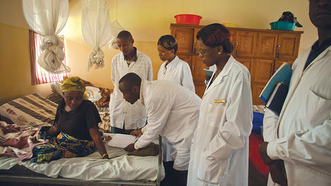 Doctors examine a woman in an African clinic setting
