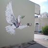 Banksy painting of a dove with a bullet proof vest and gun sights centered on it in Bethlehem