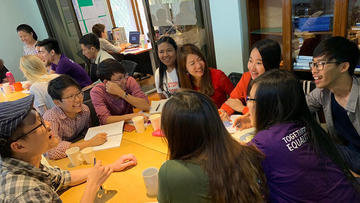 Group of students in animated conversation around a table