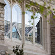 The sun shines on two small windows in Swartz Hall