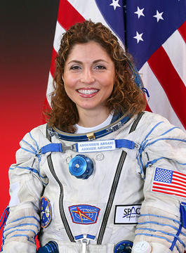 Anousheh Ansari shown her space suit in front of the American flag
