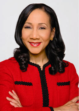 Jacqueline Y. Collins, MPA '01, MTS '03 in a red jacket with her arms crossed
