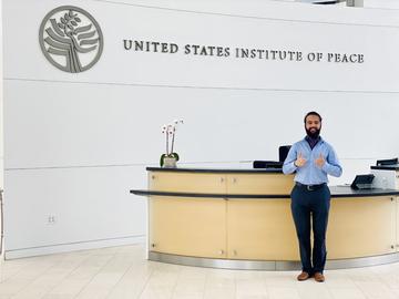 Sultan Khan, MDIV '24, poses in the lobby of the United States Institute of Peace in Washington, DC, where he completed his Certificate in Public Life Internship in Summer 2023.