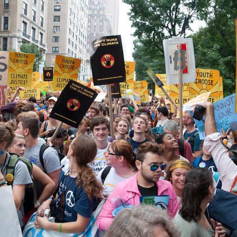 People marching through the streets of New York holding protest signs