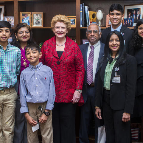 Group or people standing with a Senator in her office