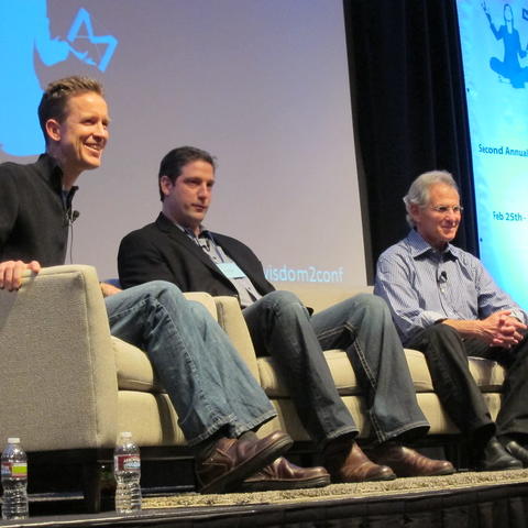 Three panel participants sitting on a stage