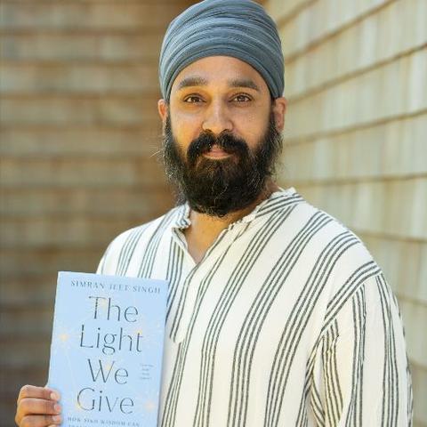 Simran Jeet Singh holds his book, The Light We Give