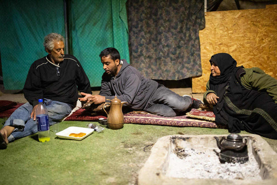 Three figures lay on the ground near two teapots