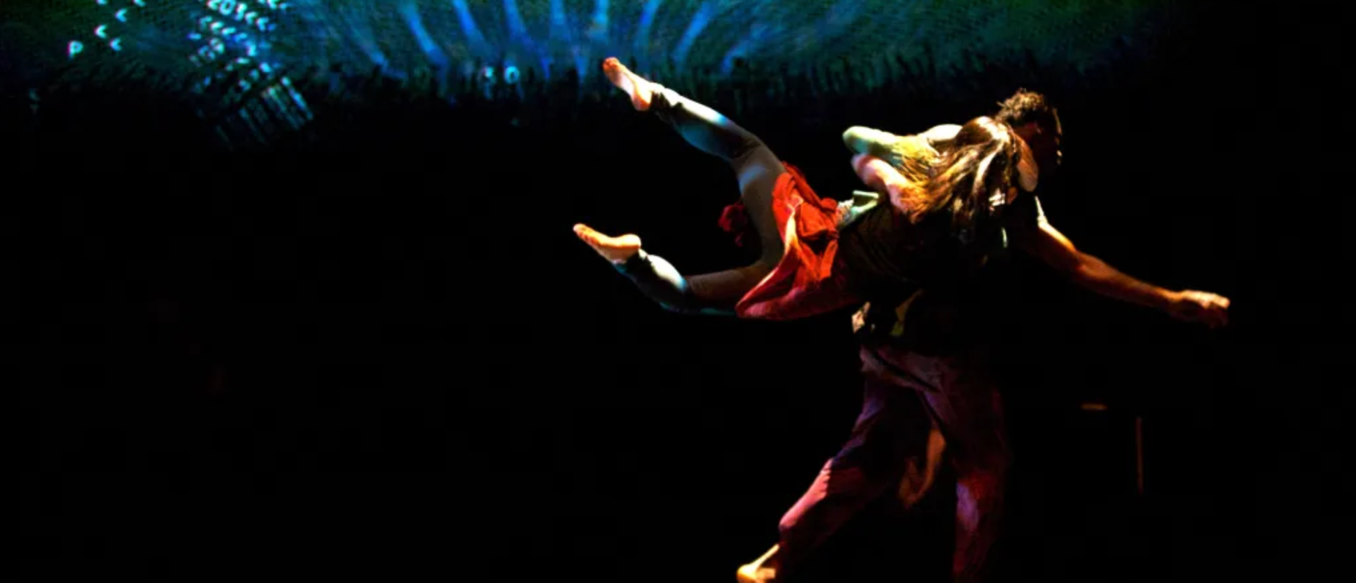 Two dancers on a dark stage with the logo of Anikaya and the title of their performance "Conference of the Birds"